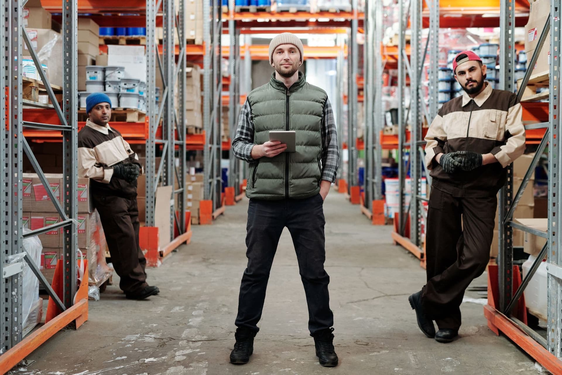 Warehouse team standing among shelves of inventory