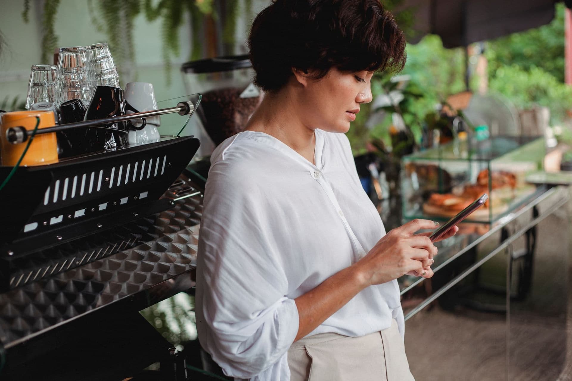Woman checking messages on her phone in a café